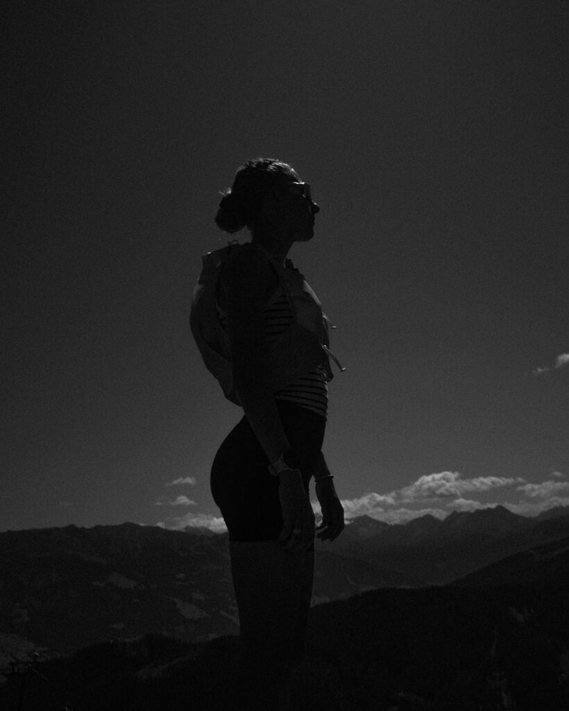 Leann Dietzel in silhouette against a mountain sky