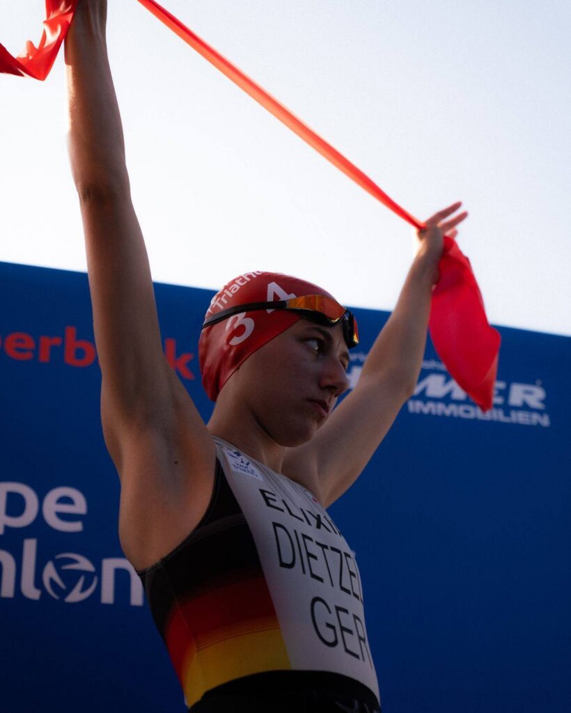 Leann Dietzel crossing the finish line of a triathlon